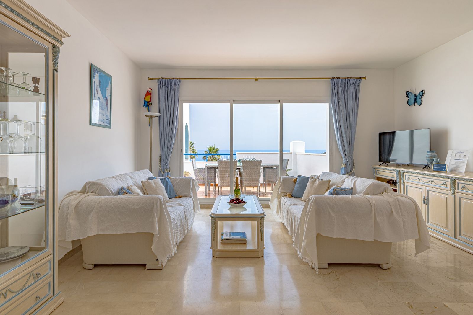 Wohnzimmer mit Sofas und raumhohen Fenstern mit Blick aufs Meer