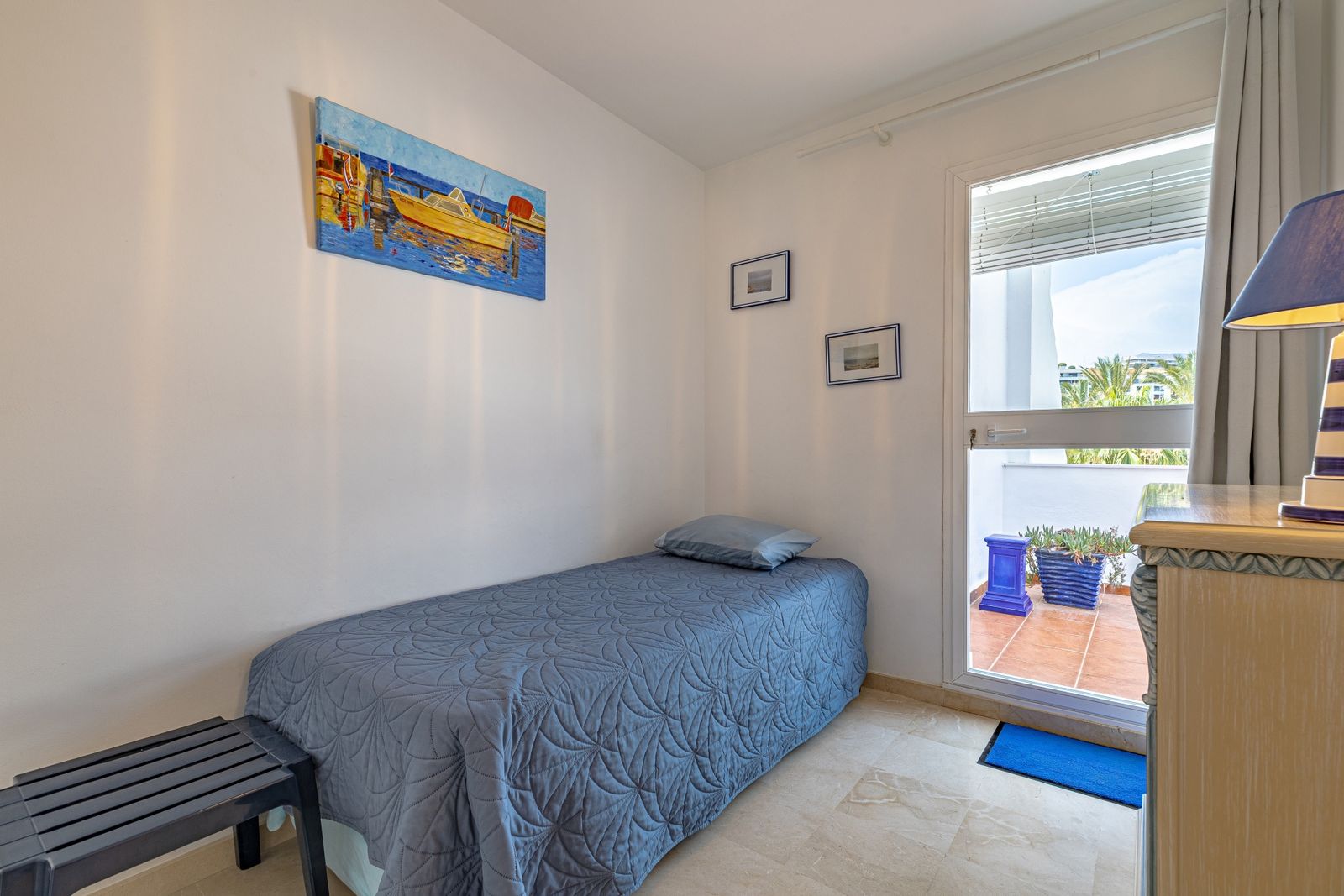 Drittes Schlafzimmer mit Einzelbett und Tür zur Terrasse